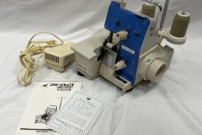 mammylock ML-702のロックミシン本体と付属品（説明書・保証書）が揃って並べられている写真。大阪市での買取品。