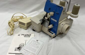 mammylock ML-702のロックミシン本体と付属品（説明書・保証書）が揃って並べられている写真。大阪市での買取品。