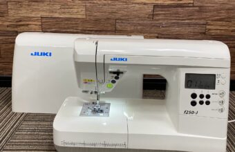 大阪市で出張買取したJUKIのコンピューターミシン「F250-J」の写真。白を基調とした本体に液晶ディスプレイと各種操作ボタンが搭載されたモデル。
